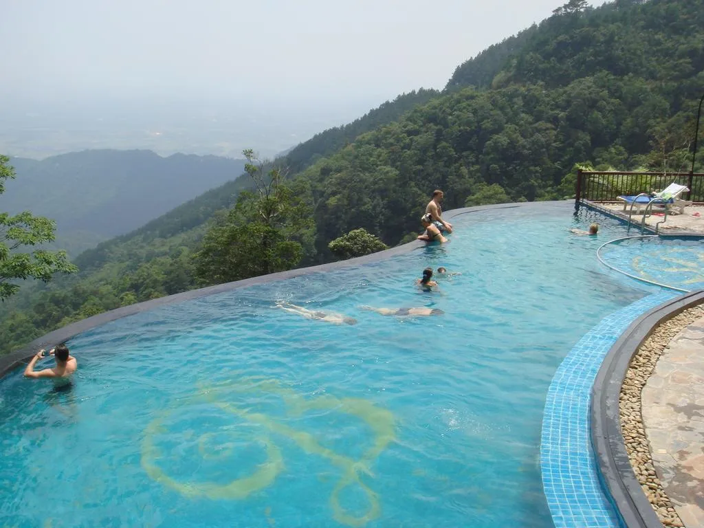 Bể bơi vô cực của Belvedere Resort Tam Đảo nằm sát mép dốc, phía sau là rừng xanh và thung lũng mờ sương