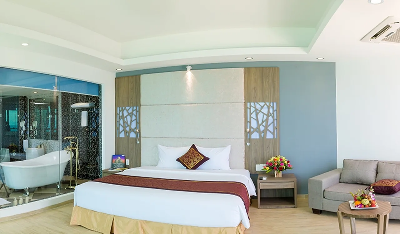 Phòng Premium Suite Ocean View tại Golden Peak Resort Nha Trang (Champarama), bồn tắm chân cao sau vách kính cạnh giường King