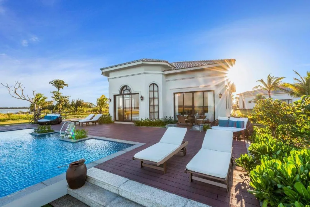Villa 4 Phòng Ngủ Ocean View Hồ Bơi Riêng của Meliá Vinpearl Cửa Hội: hồ bơi riêng, sàn gỗ và ghế tắm nắng trắng cạnh bể