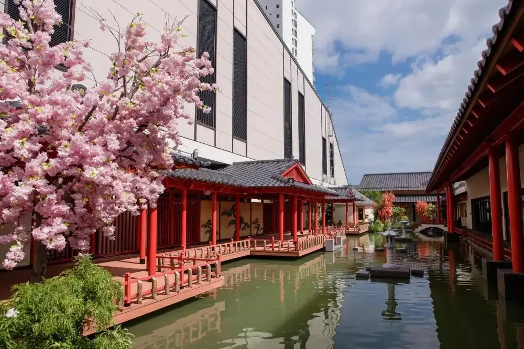 Góc vườn Nhật tại Mikazuki Japanese Resorts & Spa với cây hoa anh đào, hành lang cột đỏ và hồ nước