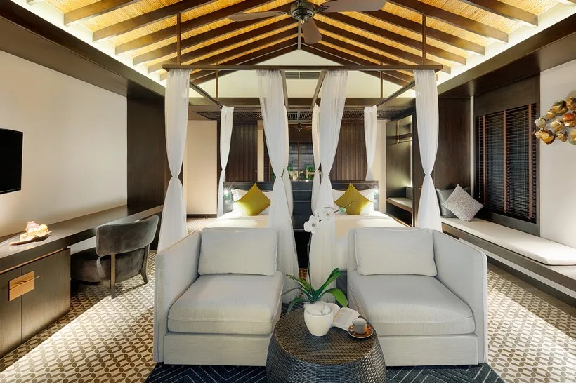 Phòng Sunset Villa tại Nam Nghi Phu Quoc với trần gỗ tre, giường buông màn trắng, ghế bành và sàn gạch bông