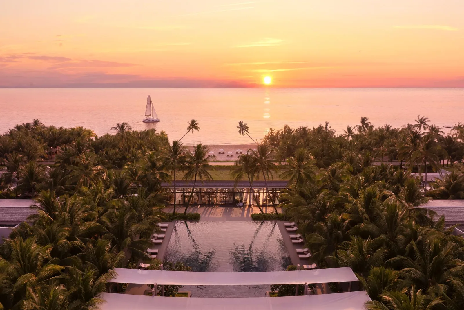 Hoàng hôn trên biển Bãi Trường nhìn từ Regent Phu Quoc, hồ bơi giữa rừng dừa và thuyền buồm ngoài khơi