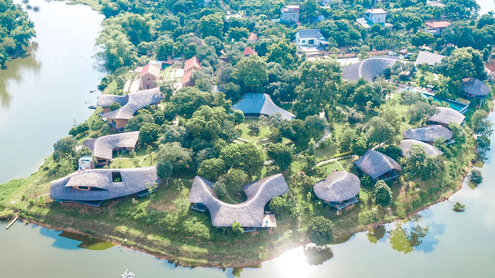 Toàn cảnh từ trên cao các villa mái tranh cong của Tomodachi Retreat - Muong Village trên bán đảo giữa hồ